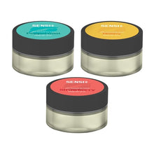 Load image into Gallery viewer, Three cosmetic jars labeled "Sensi Skin" are shown, each containing a different flavor variant: mint-green for "Peppermint," yellow-orange for "Honey," and red for "Strawberry." These vegan-friendly Sensi Skin 100mg CBD Lip Balms have black lids and transparent bases revealing the vibrant colors inside, with each jar featuring 100mg of CBD. Don't miss the special offer: buy one and get one free!