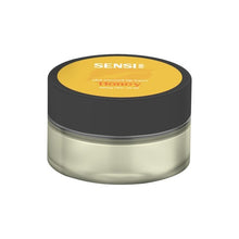 Load image into Gallery viewer, A small, round container with a black lid and transparent body, displaying a yellow label on top. The label reads "Sensi Skin" and "CBD Infused Lip Balm Honey" in white text. This vegan-friendly product contains 100mg CBD and holds 25ml of balm or cream.
